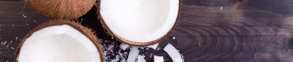 Coconut halves with shell on a dark background. Top view with copyspace