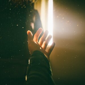 A hand reaching out to a divine light